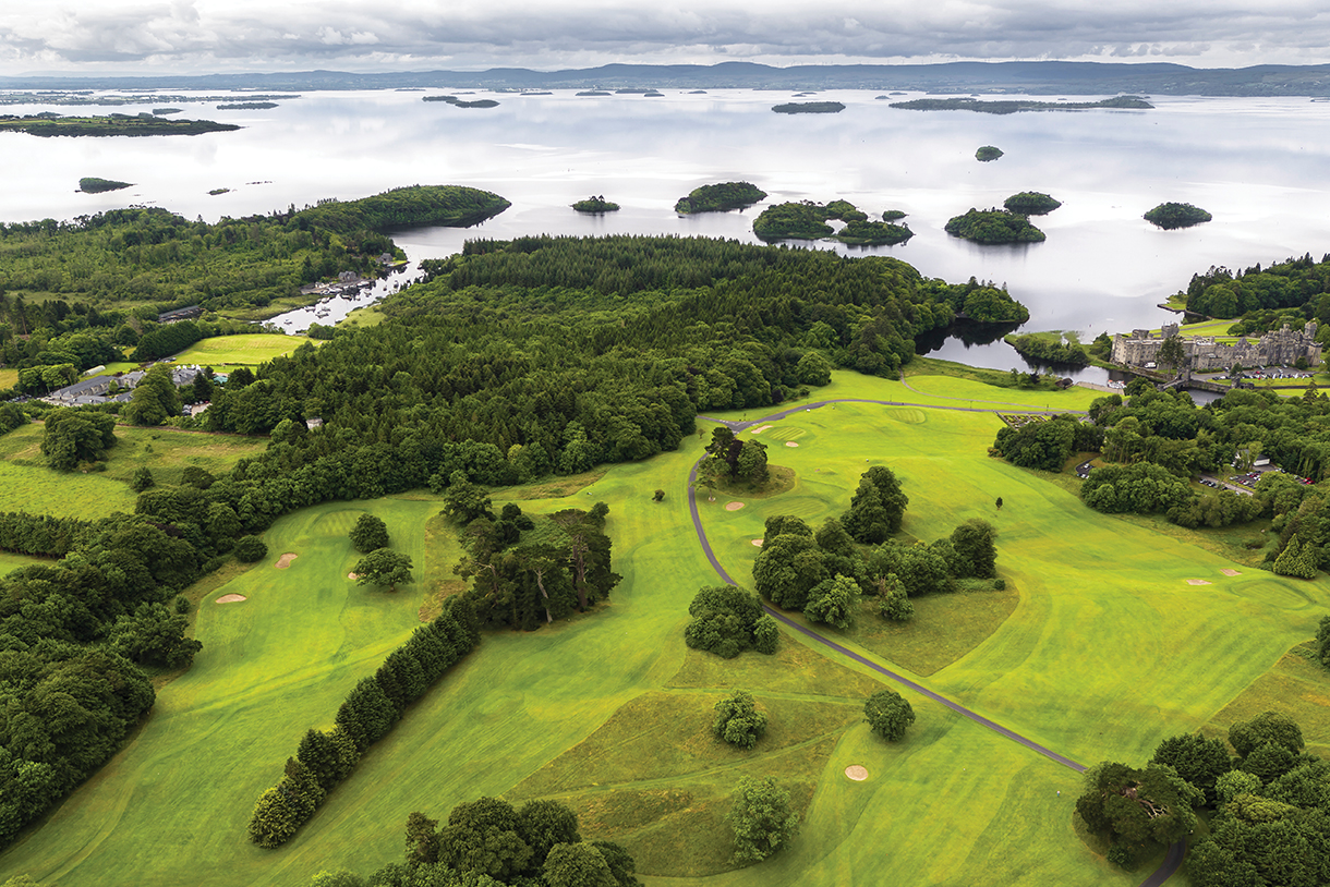 Ashford Castle surrounded by beautiful green forests and landscaping overlooking shores of Lough Corrib